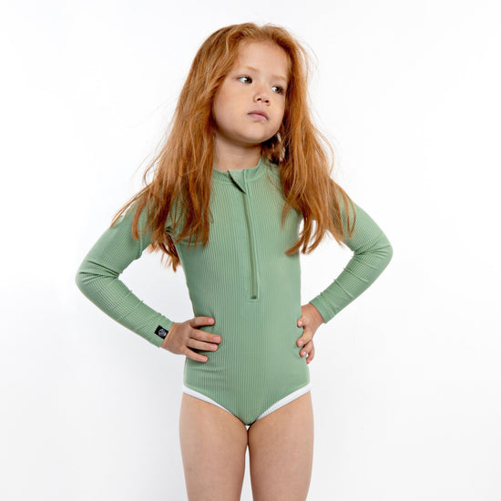This picture shows a girl in a ribbed basil green, UPF50+ long sleeve swimsuit