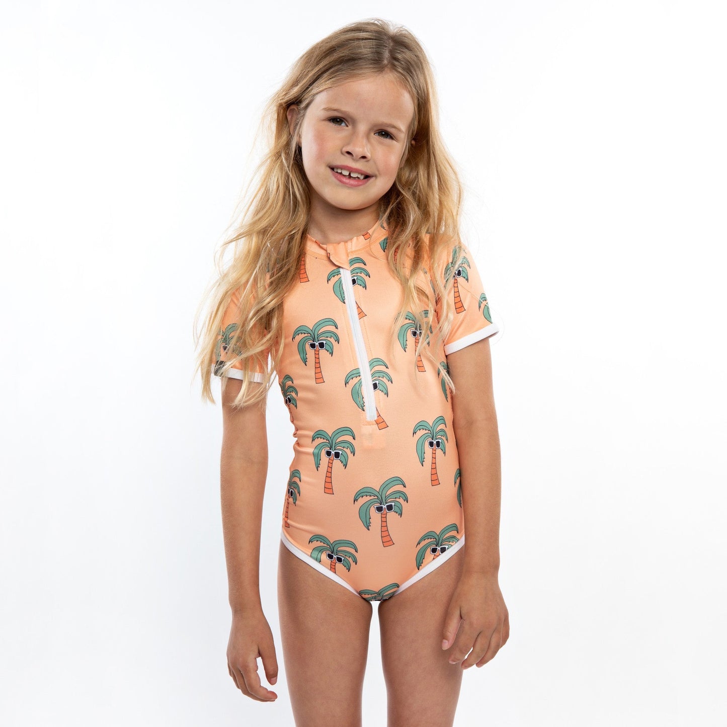 This picture shows a girl in the Palm Breeze print, UPF50+ short sleeve swimsuit