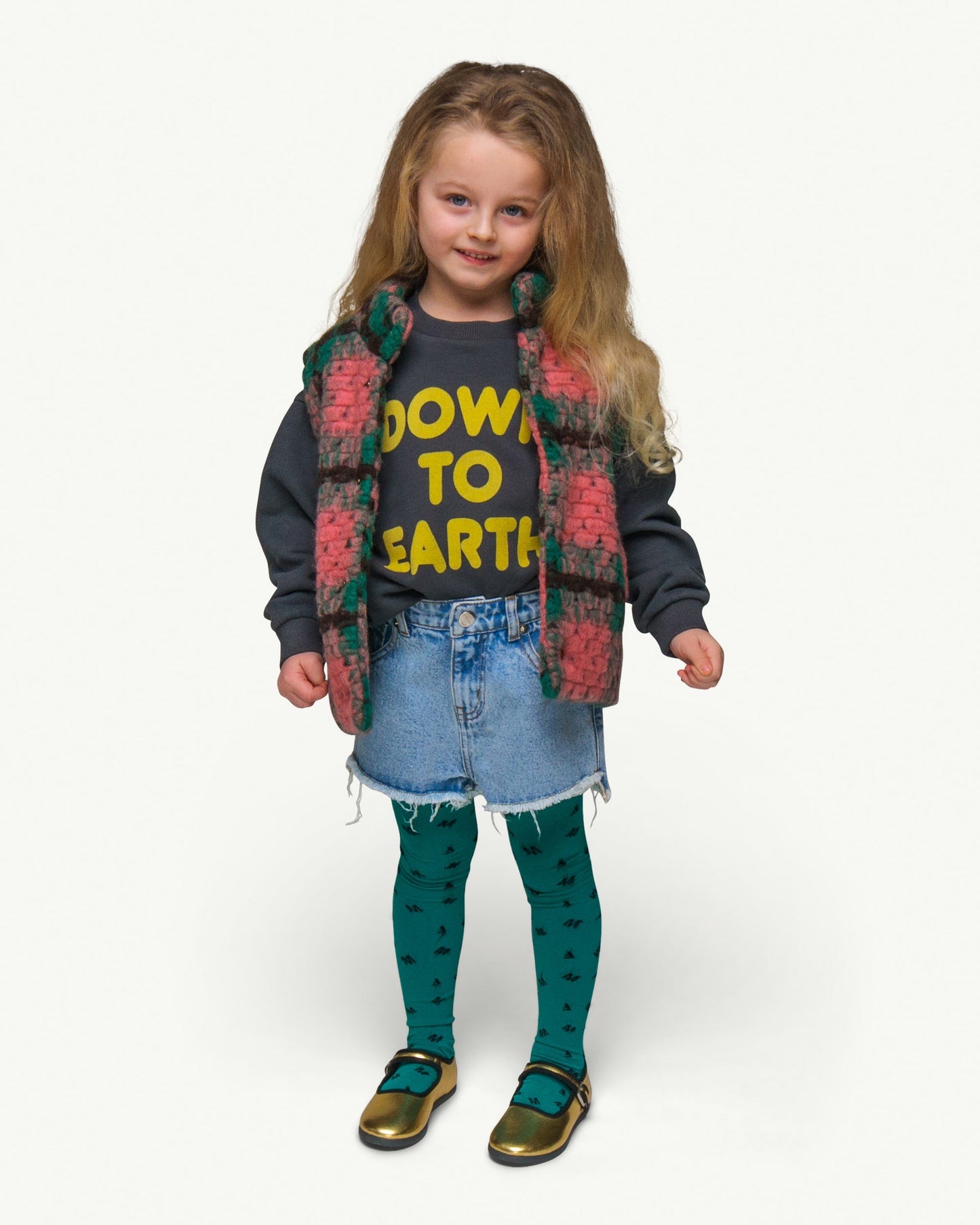 This picture shows a girl wearing the vintage black Sweater in a soft organic cotton fabric brushed on the inside with a bright yellow flock print text