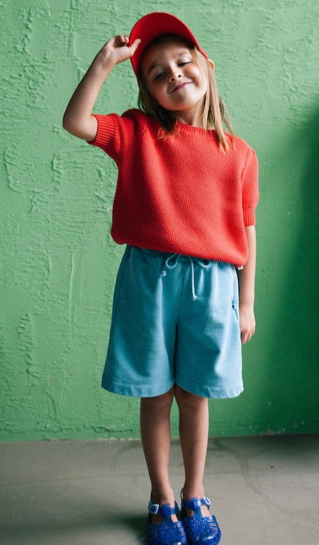 This picture shows a girl wearing the organic cotton light blue sweat shorts. 