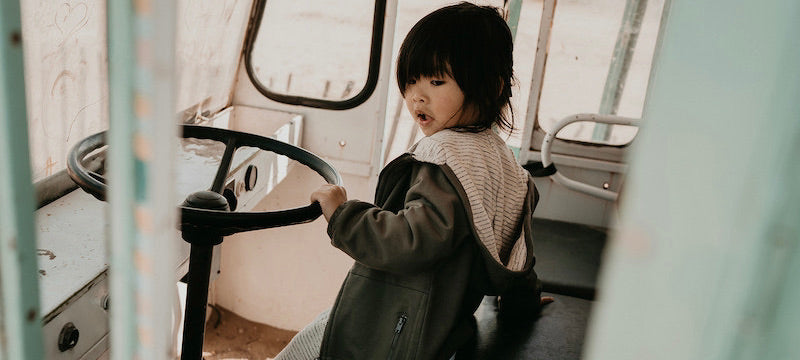 New Gots Organic Kidswear Collection. This Picture shows a child wearing a olive hooded sweat with zipper at the front. 