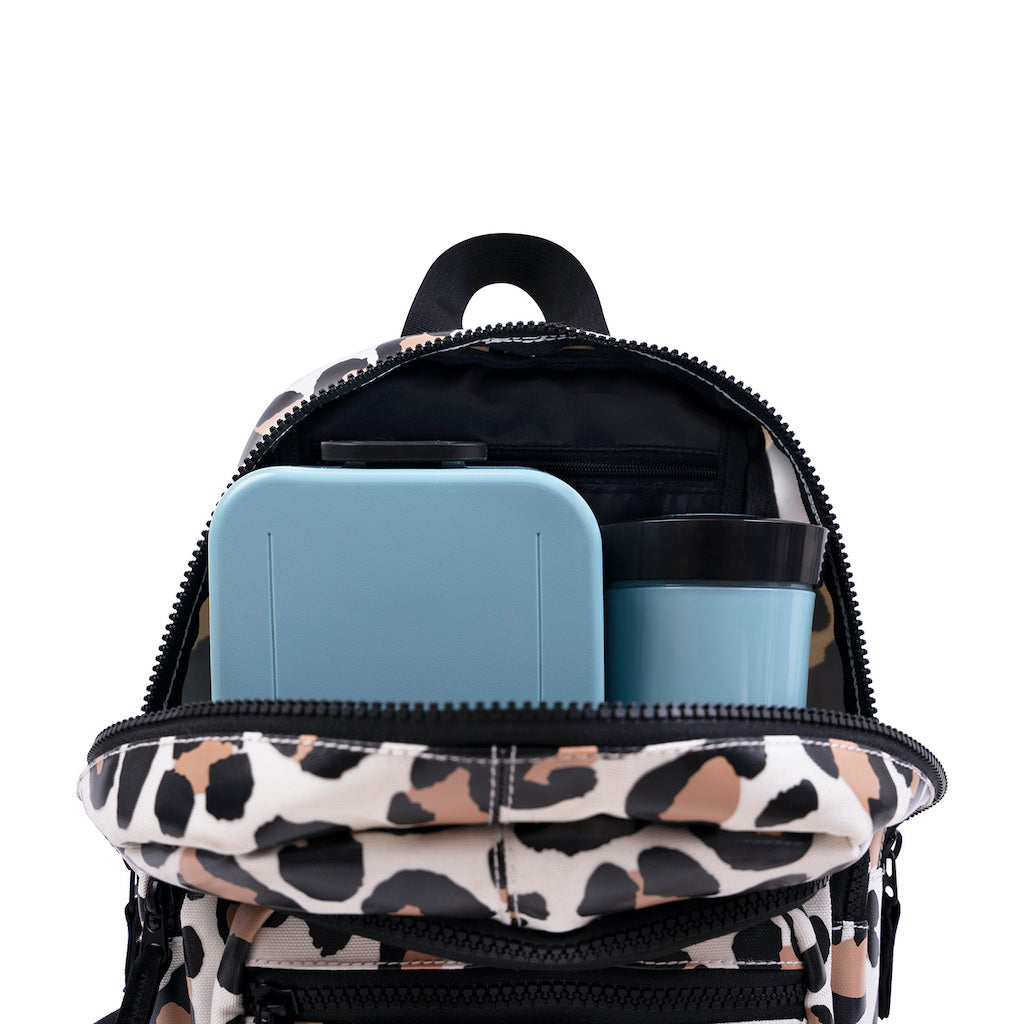 This picture shows a kids backpack in leopard print. Made from recycled plastic. Adjustable comfort straps. Front pocket with zip. Two Pockets inside for lunchbox and bottle. Large padded compartment. 