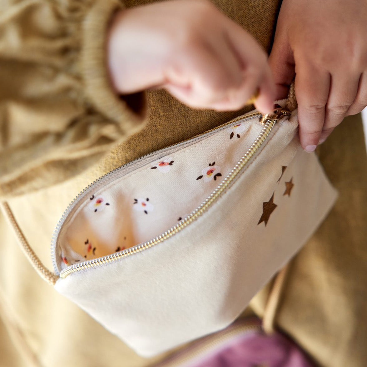 A cute little white handbag for your little misses. Made of soft velvet, beautiful cotton floral interior, closes with a zipper and has a cute tassel.