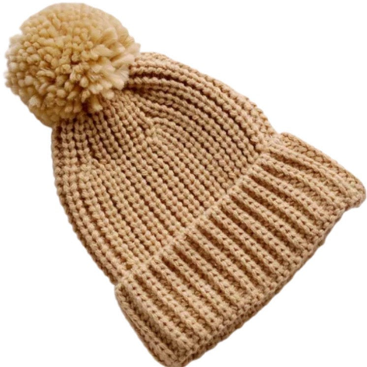 This picture shows a chunk knit winter beanie for toddlers and kids. with pom pom. Colour Nutmeg