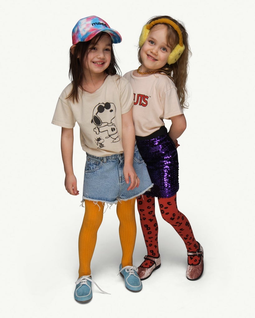 This picture shows two girls wearing the Peanuts Collab tees from Maed for Mini. One has Snoopy and one tee has Peanuts on the front