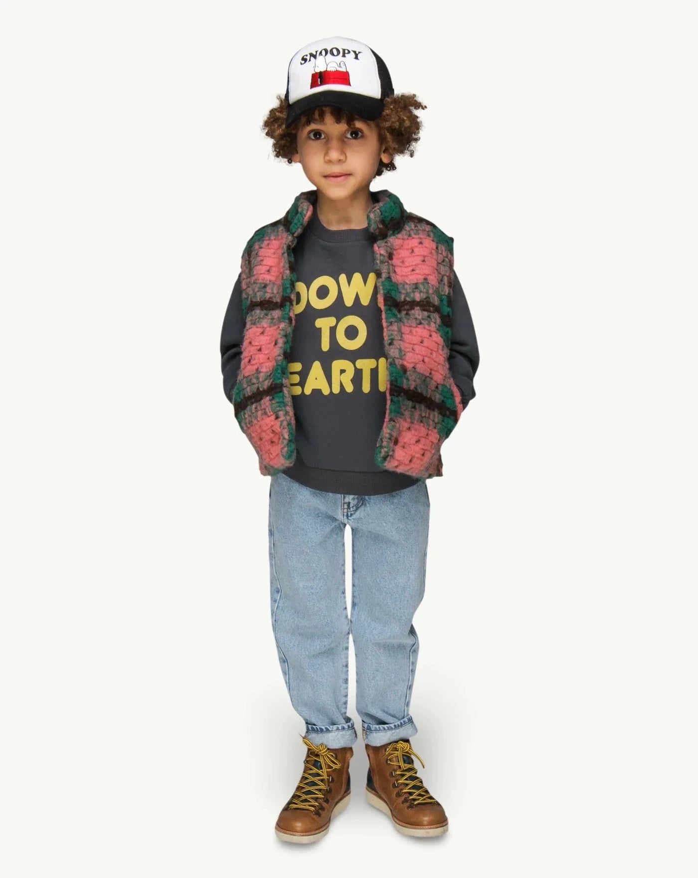 This picture shows a boy wearing a vintage black Sweater in a soft organic cotton fabric brushed on the inside with a bright yellow flock print text