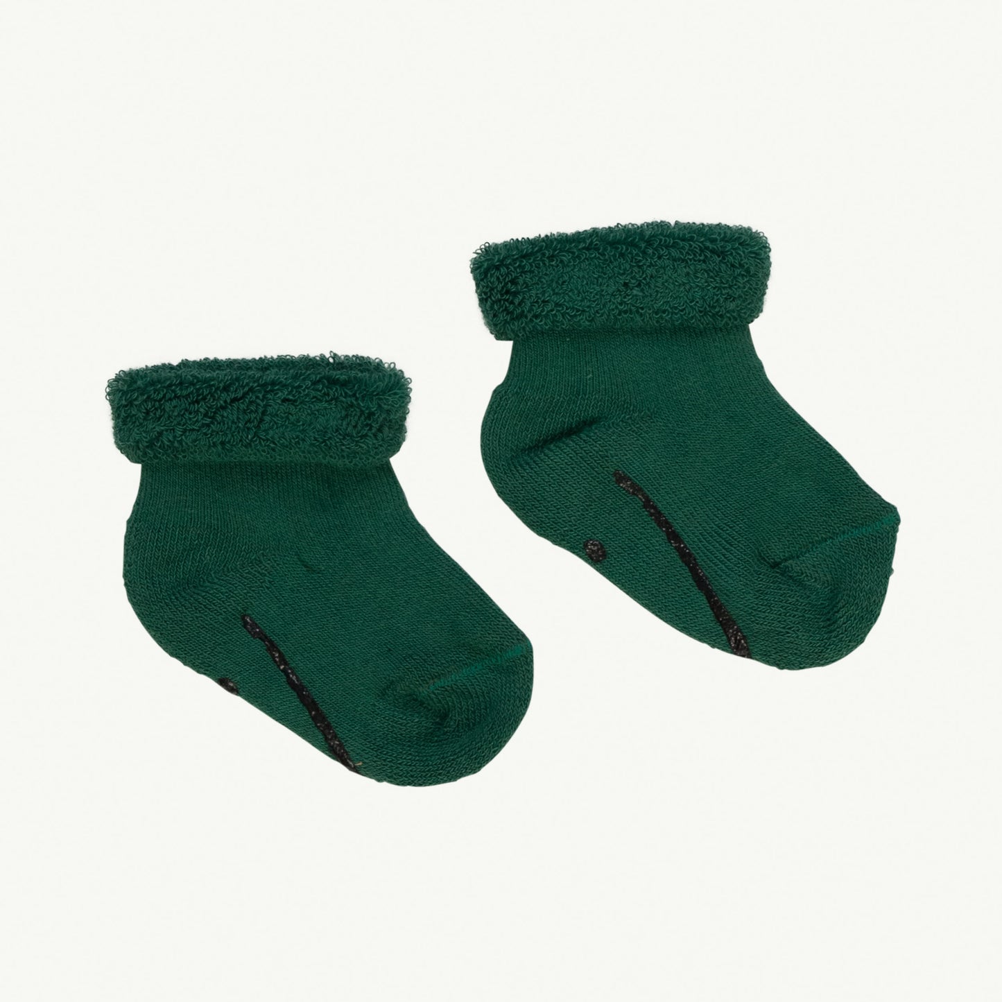This picture shows green organic cotton baby socks with an anti slip smily print at the bottom.