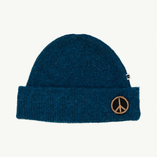 This picture shows a soft knitted blue beanie with a peace patch