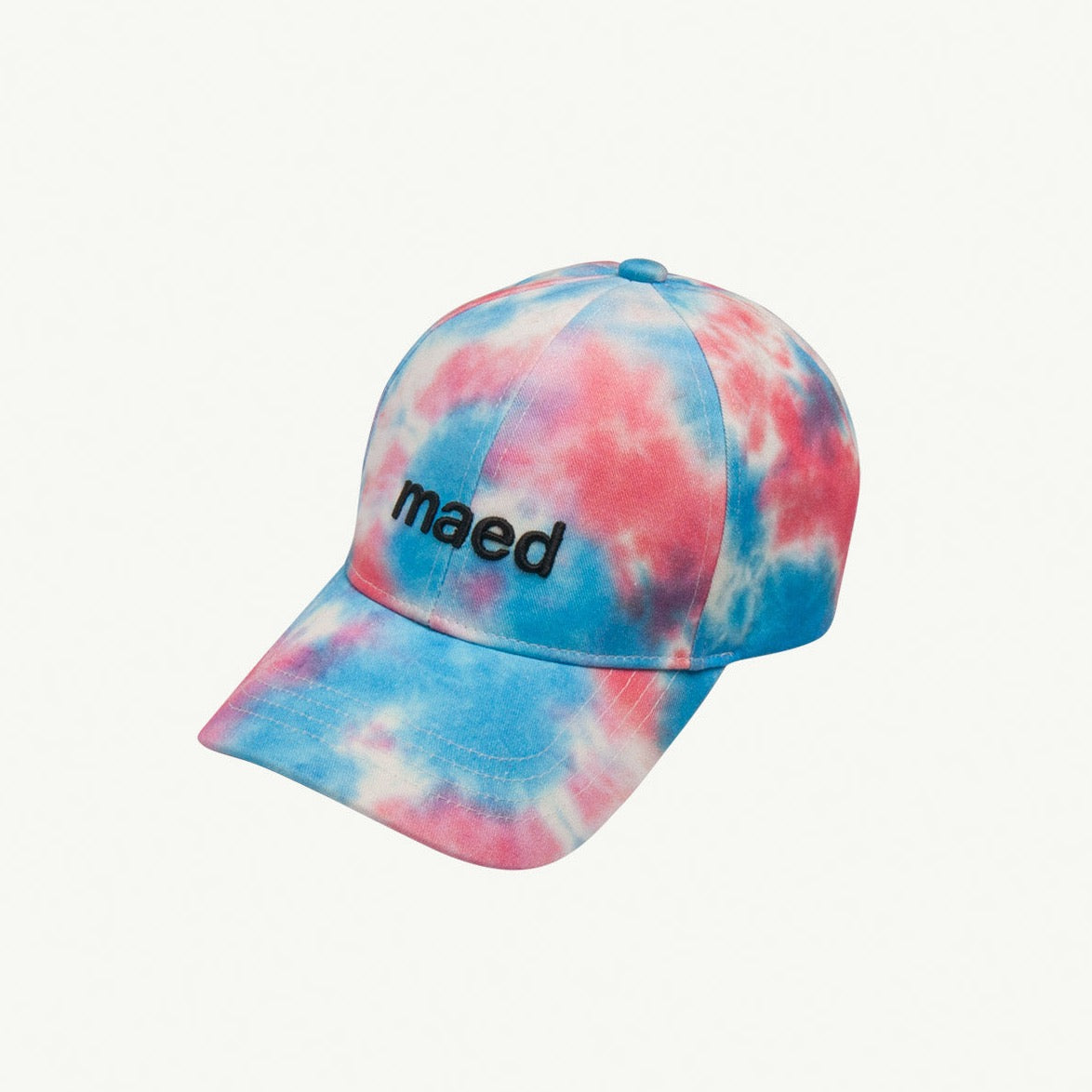 This picture shows a fitted cap with a pink and blue tie dye print. It has an adjustable strap at the back. 