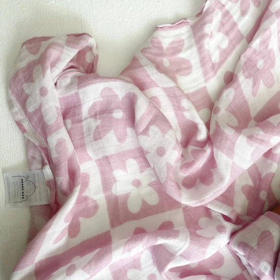 This picture shows the Bamboo/cotton Swaddle wrap with a pink soli print of checks and flowers
