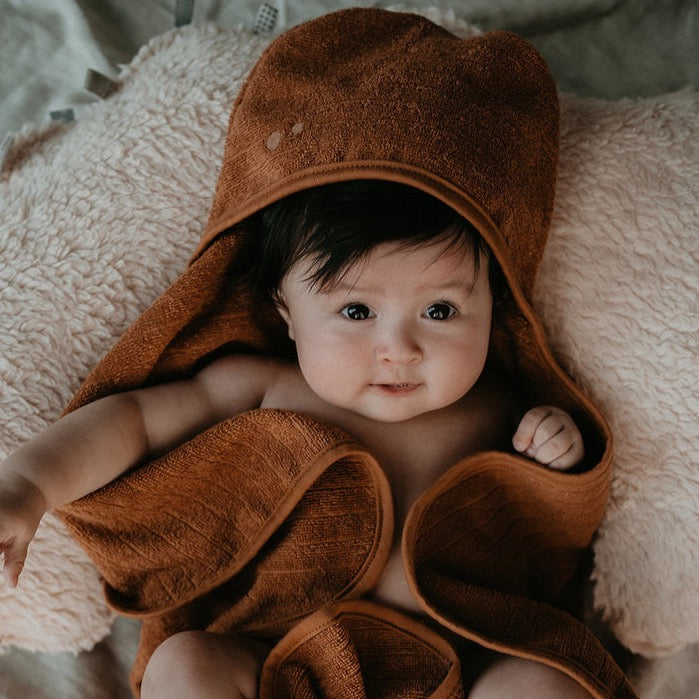 This picture shows a baby wrapped in a organic hooded baby towel. 