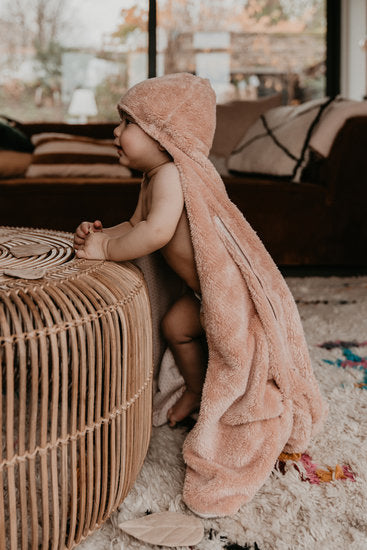 This picture shows a baby in a Organic Baby Wrapping Blanket - Milky Rust