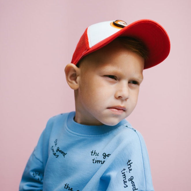 This picture shows a boy wearing the red sporty kids cap with a mesh back and a adjustable strap. Cool tiger badge on the front.